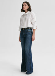 Woman wearing a white shirt and blue jeans on a white background