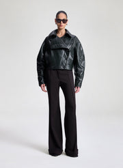 woman wearing dark green leather jacket and dark brown pants