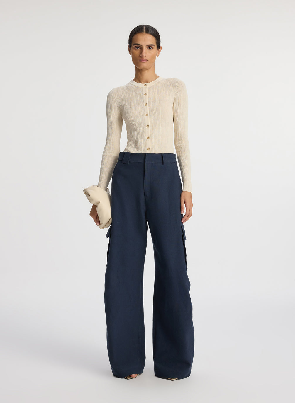 front view of woman wearing white cardigan and navy blue cargo pants