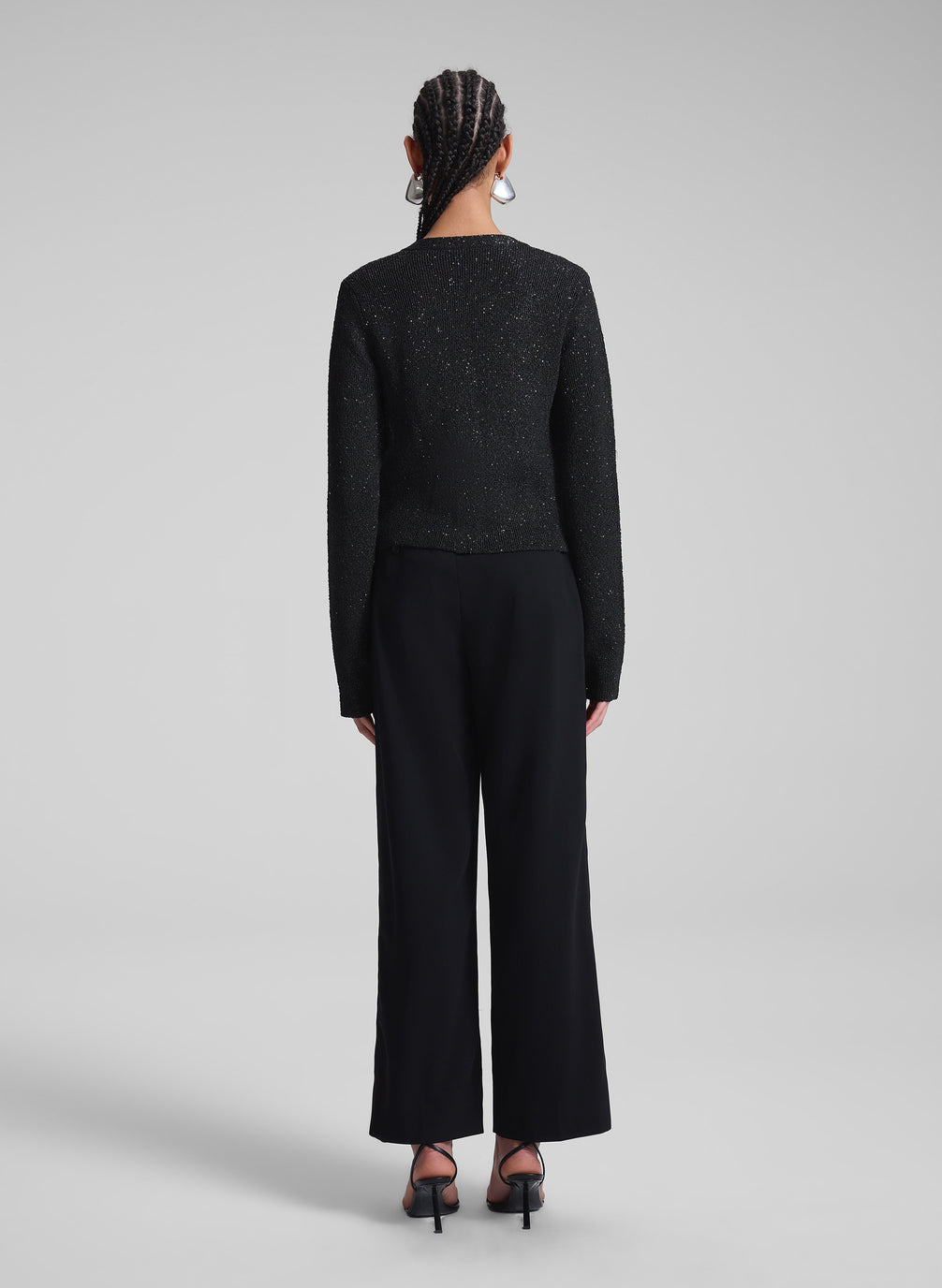 woman wearing black sequin cardigan and black pants