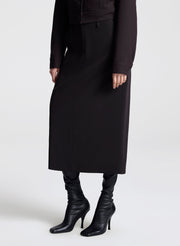 woman wearing a dark brown jacket and matching skirt