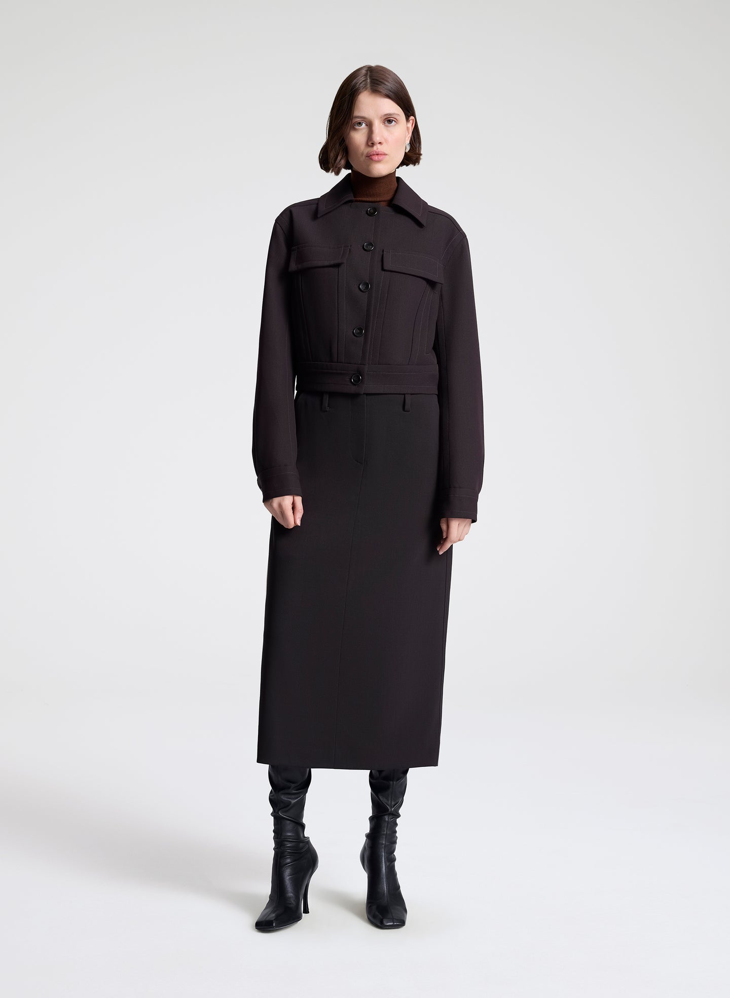 woman wearing a dark brown jacket and matching skirt