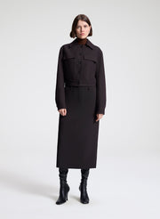 woman wearing a dark brown jacket and matching skirt