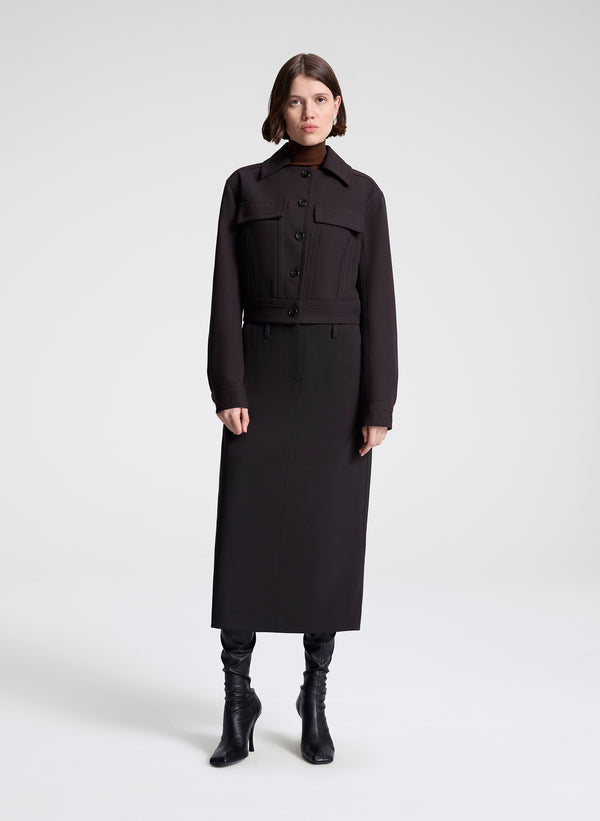 woman wearing a dark brown jacket and matching skirt