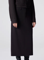 woman wearing a dark brown jacket and matching skirt