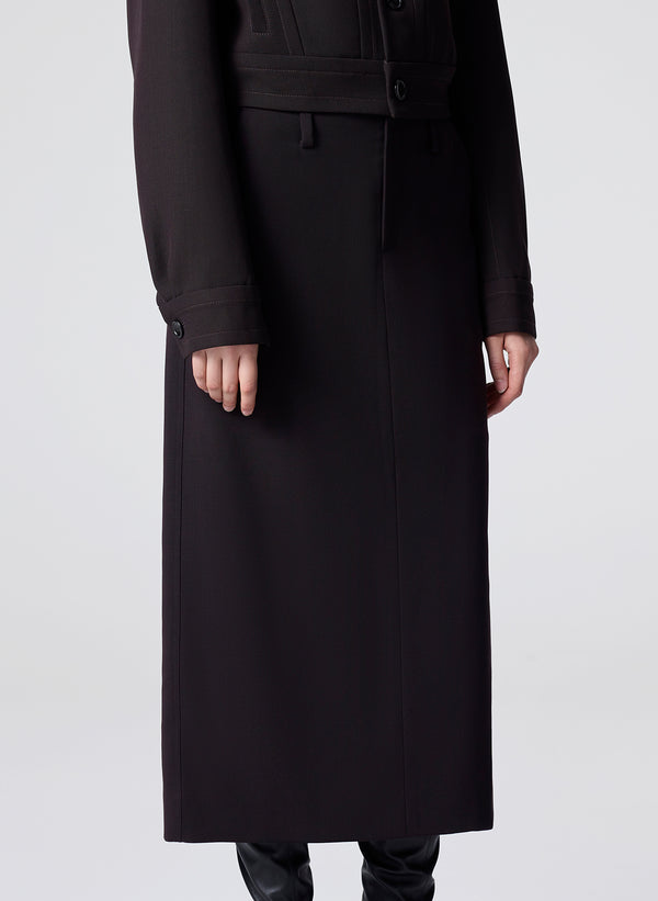 woman wearing a dark brown jacket and matching skirt