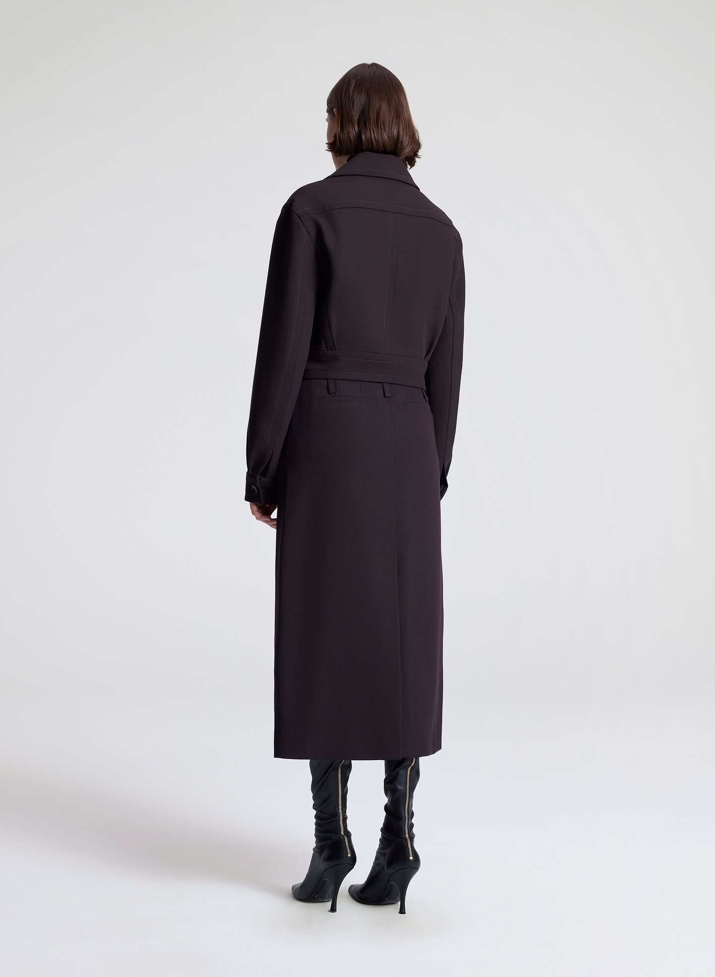 woman wearing a dark brown jacket and matching skirt