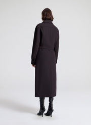 woman wearing a dark brown jacket and matching skirt