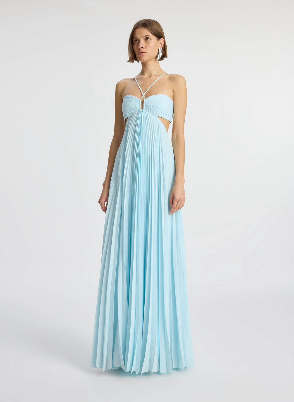 side  view of woman wearing aqua satin pleated gown