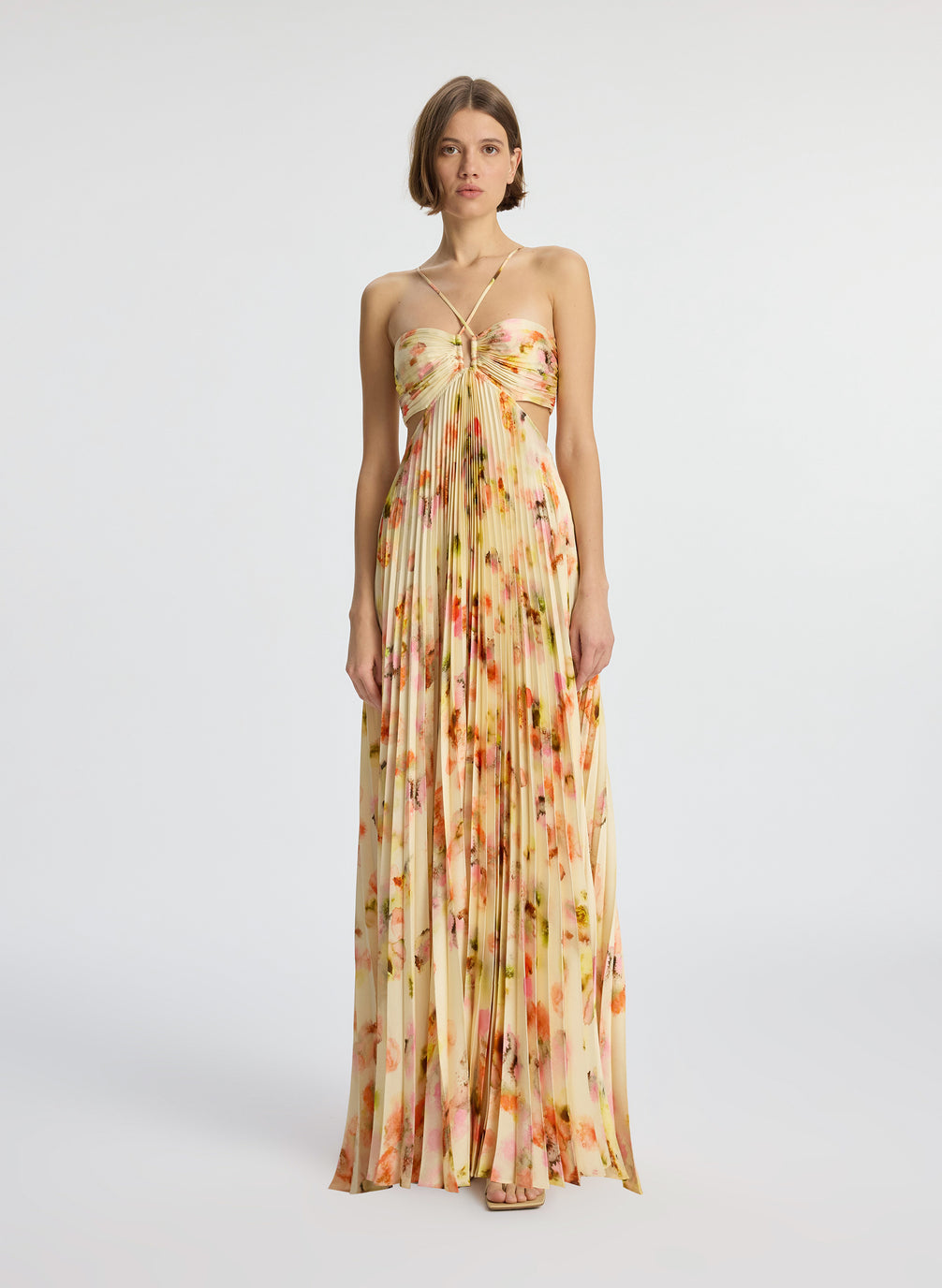 front view of woman wearing yellow pleated maxi dress