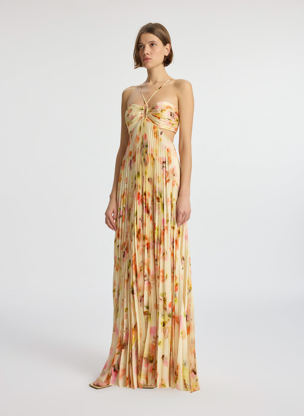 side view of woman wearing yellow pleated maxi dress