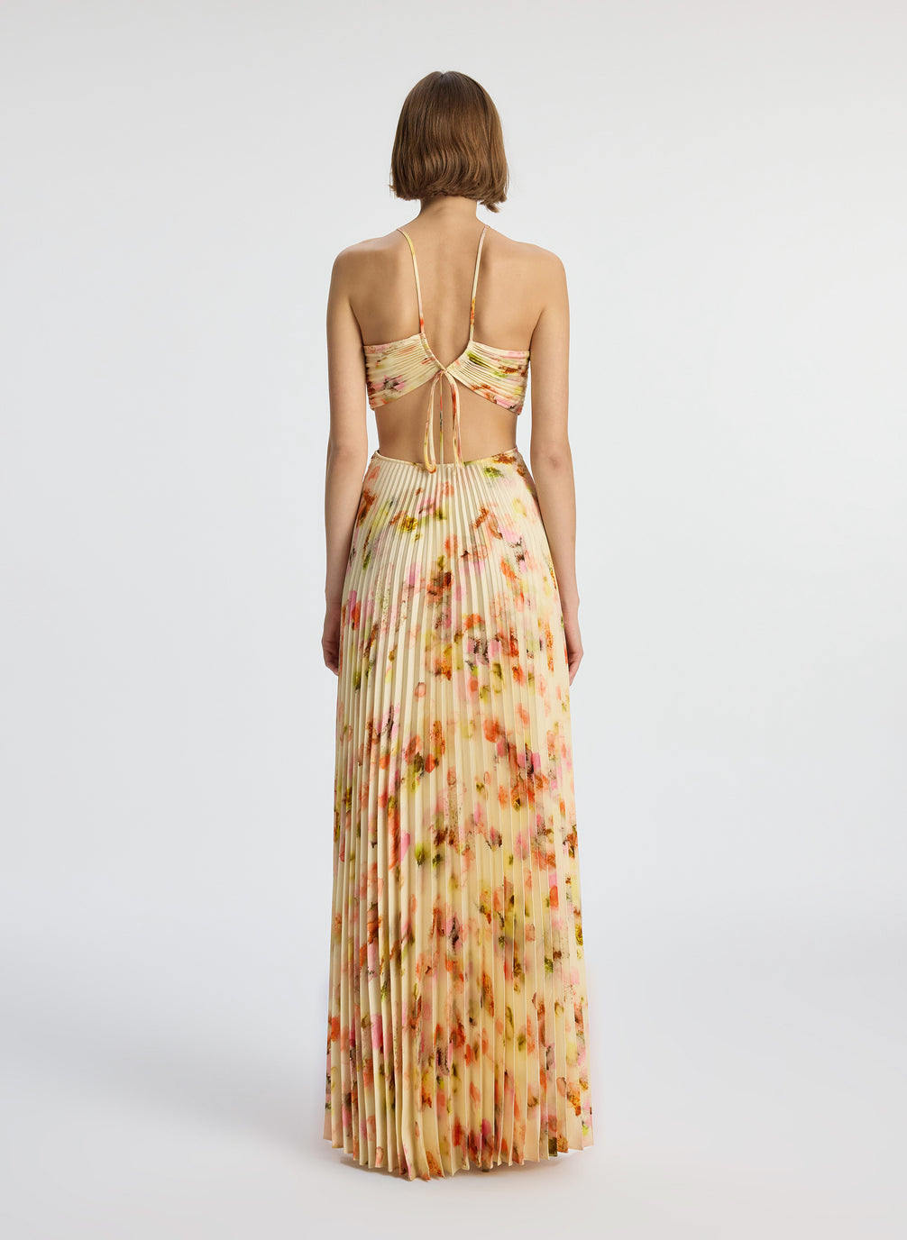 back view of woman wearing yellow pleated maxi dress