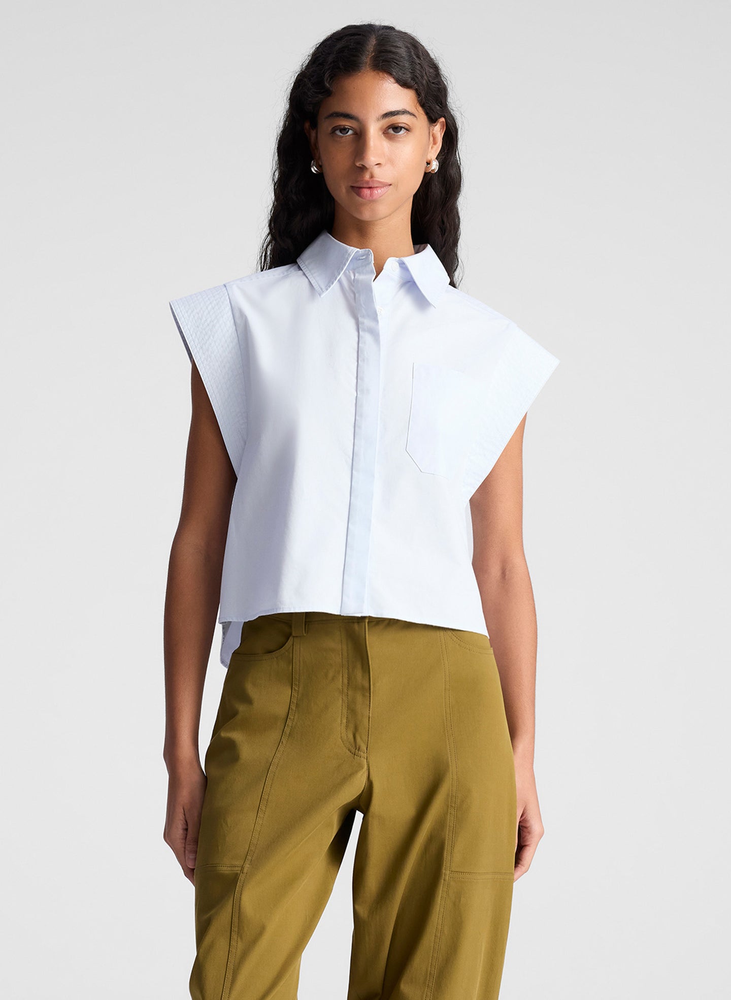 woman wearing light blue top and green pants