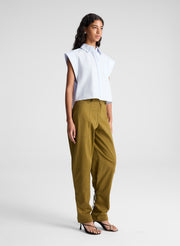 woman wearing light blue top and green pants