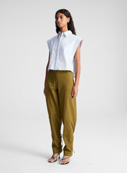 woman wearing light blue top and green pants