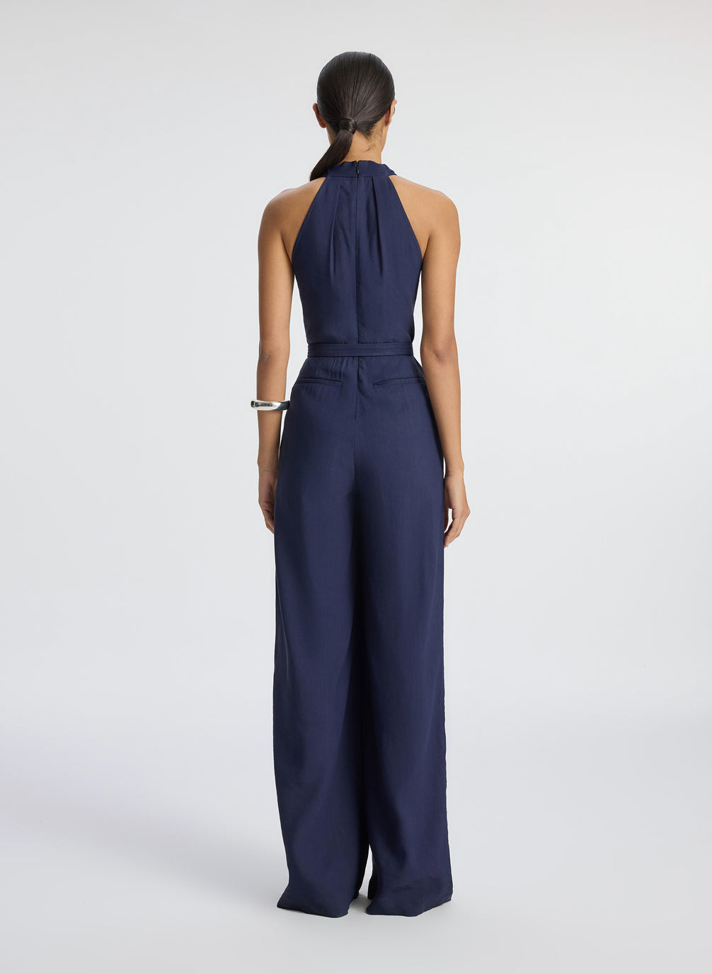 back view of woman wearing navy blue sleeveless jumpsuit