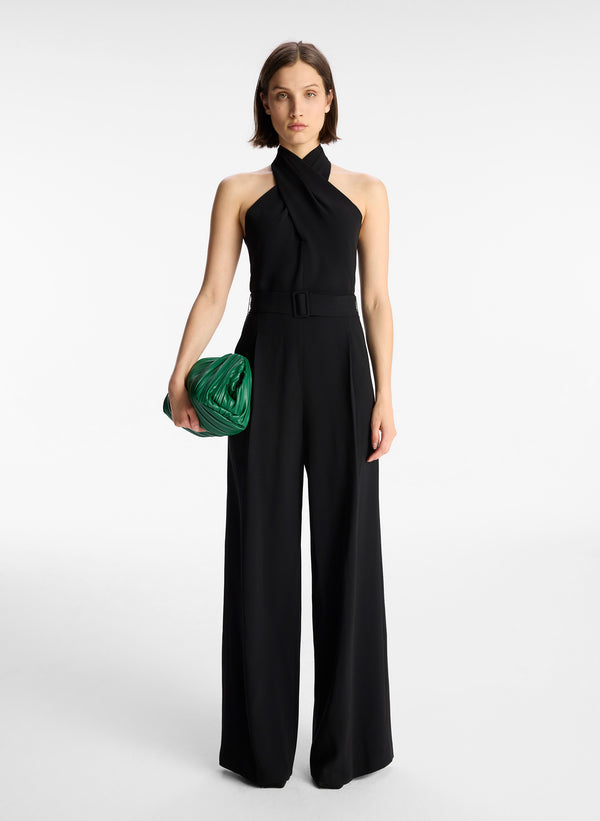 front view of woman in black sleeveless wide leg jumpsuit