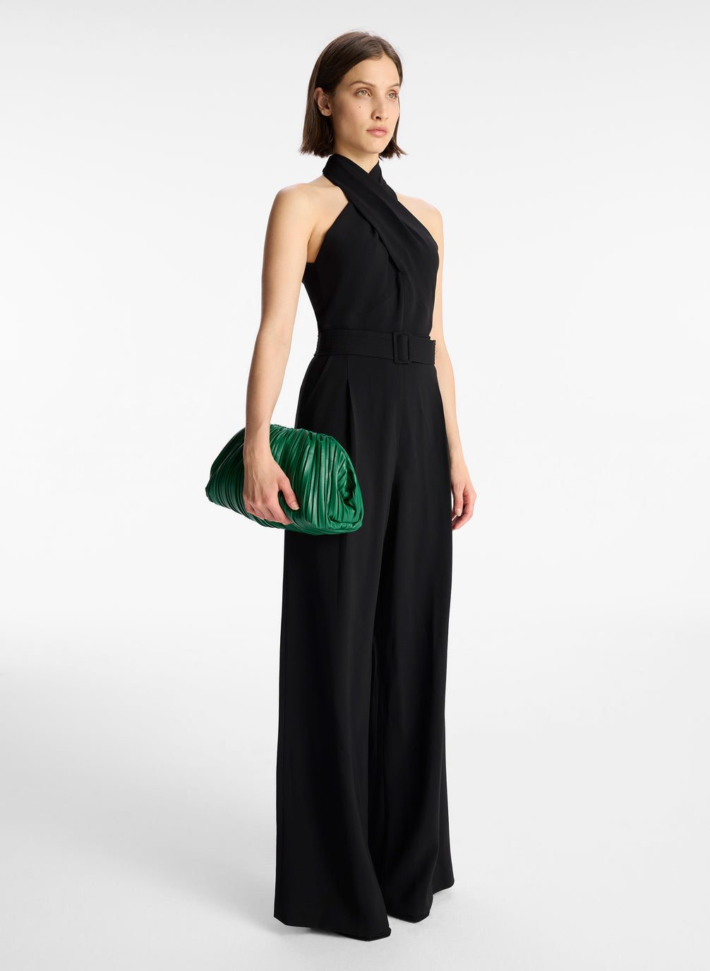side view of woman in black sleeveless wide leg jumpsuit