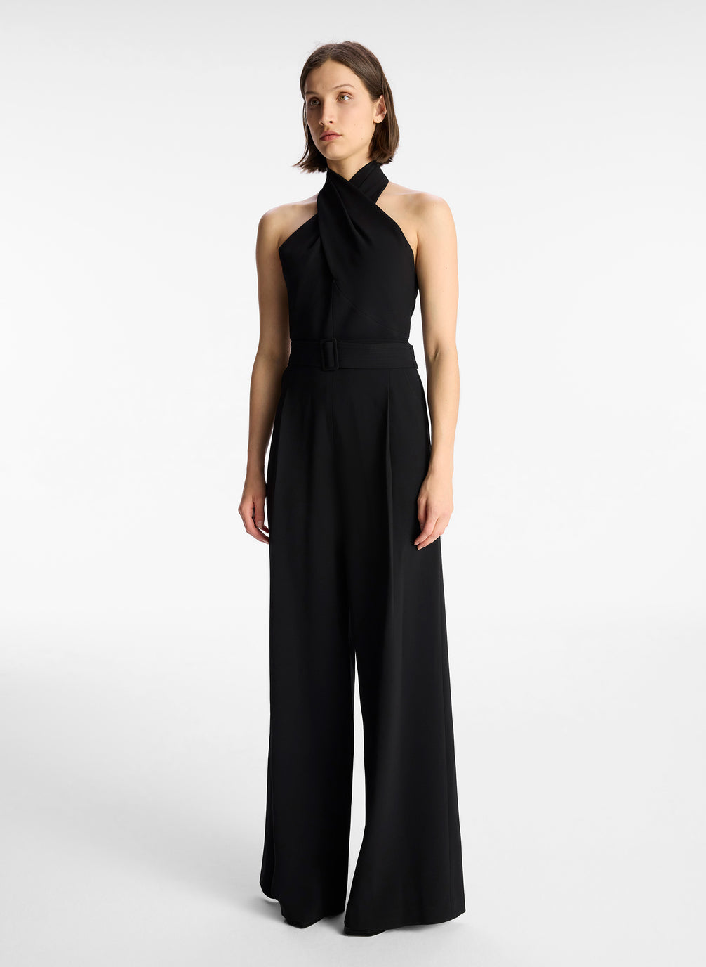 side view of woman in black sleeveless wide leg jumpsuit