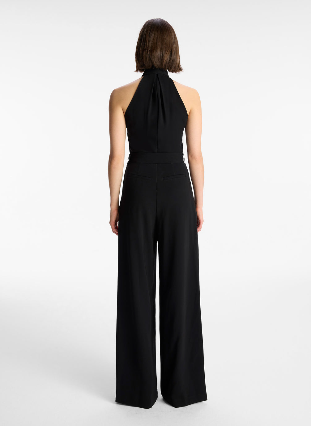 back view of woman in black sleeveless wide leg jumpsuit