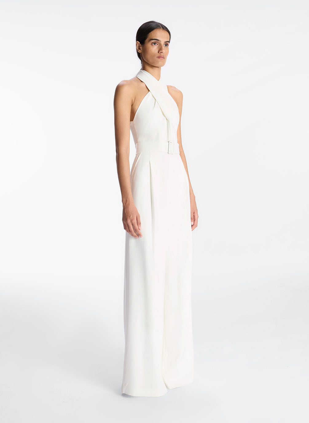 side view of woman in white sleeveless wide leg jumpsuit
