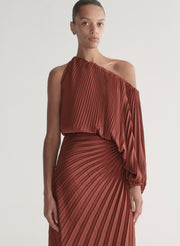woman wearing maroon satin pleated one shoulder top and matching maxi skirt