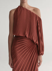 woman wearing maroon satin pleated one shoulder top and matching maxi skirt