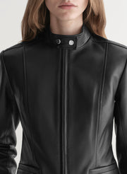 Close-up of a person wearing a black leather jacket with a white background