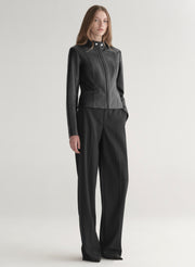 Person wearing a black leather jacket and pants on a white background