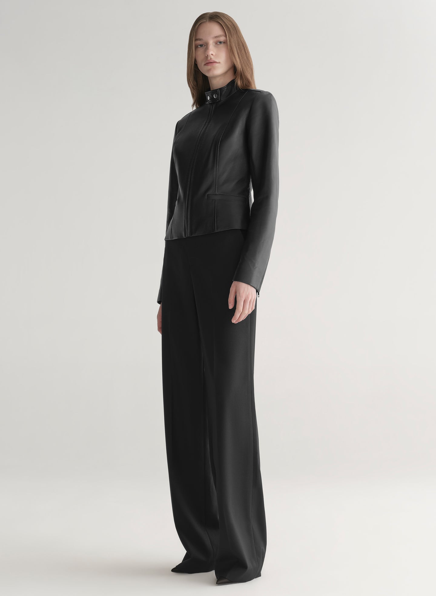 Person wearing a black outfit on a light gray background