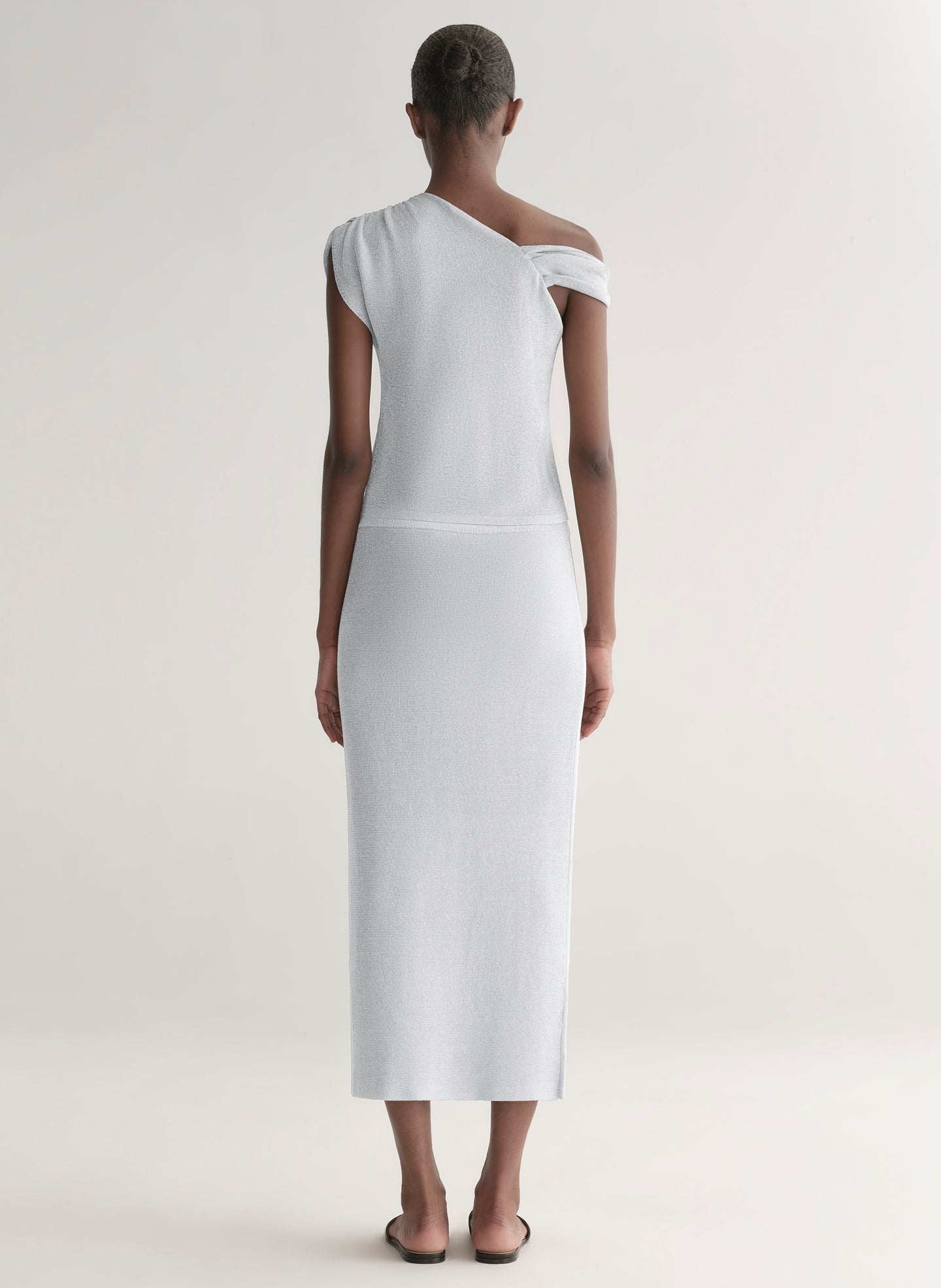 woman wearing silver knit top and matching midi skirt