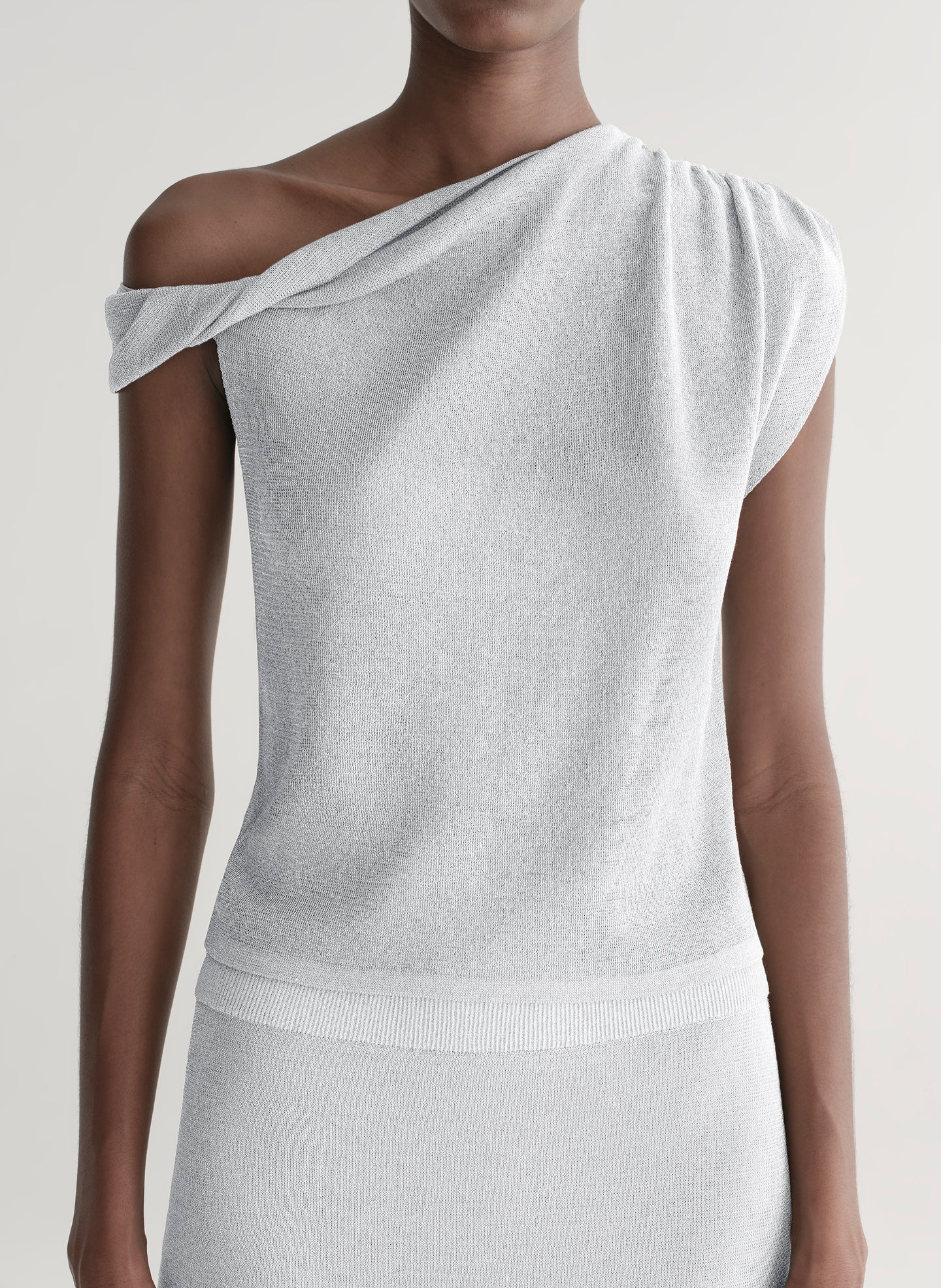 woman wearing silver knit top and matching midi skirt