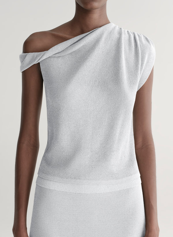 woman wearing silver knit top and matching midi skirt