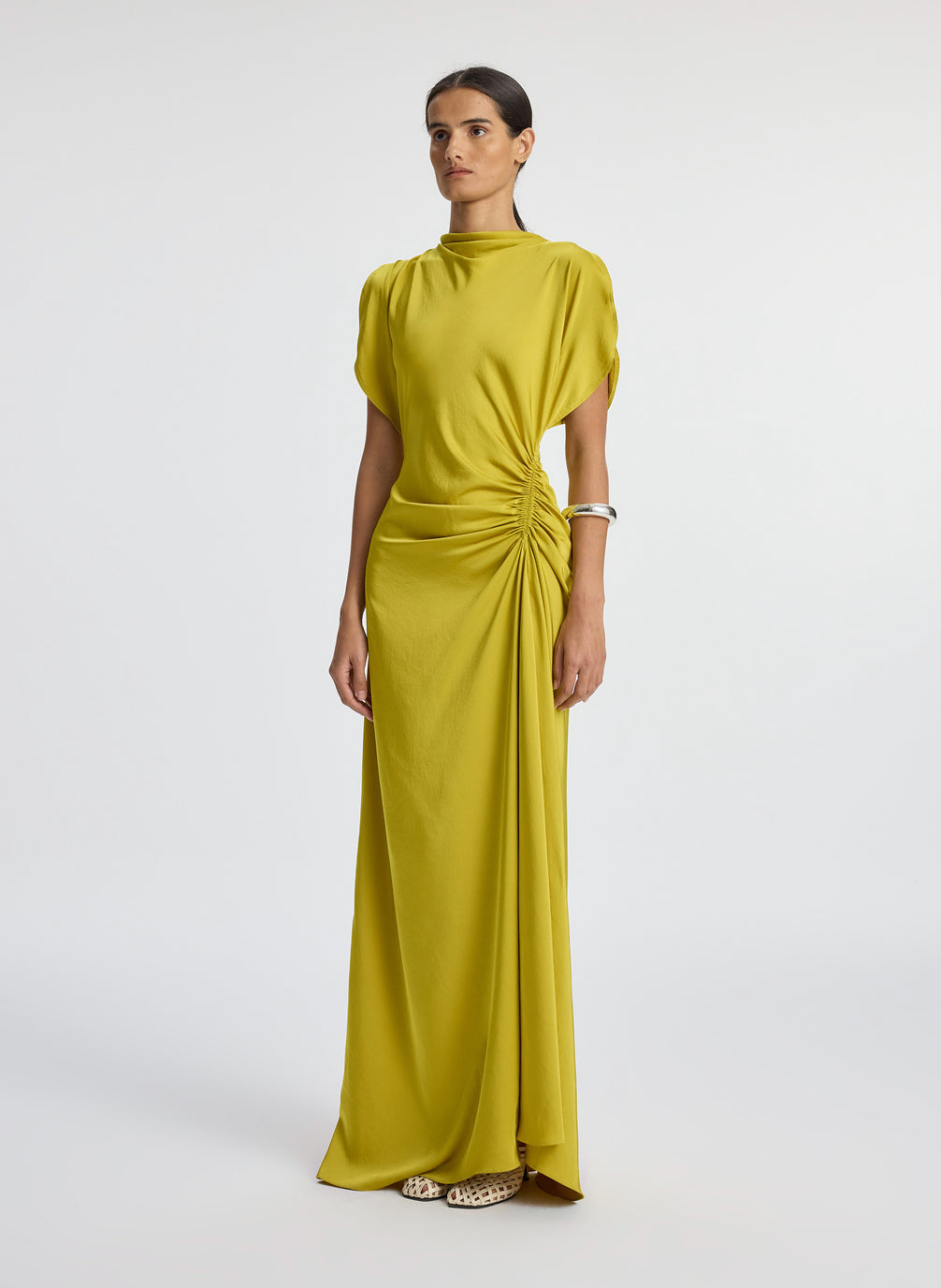 side view of woman wearing yellow satin short sleeve gown