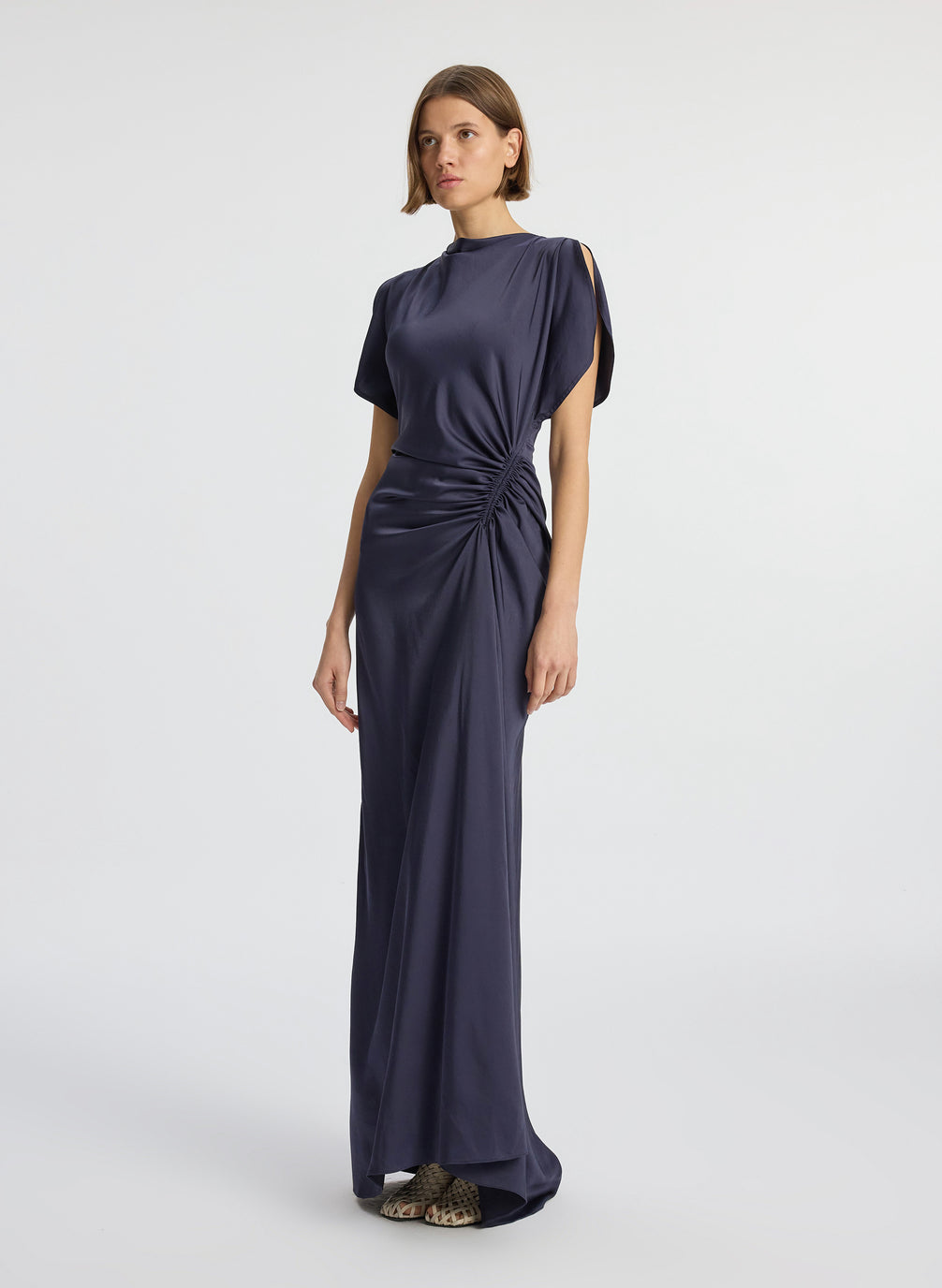 side view of woman wearing navy blue short sleeve satin gown