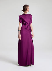 Woman wearing a long purple dress on a white background