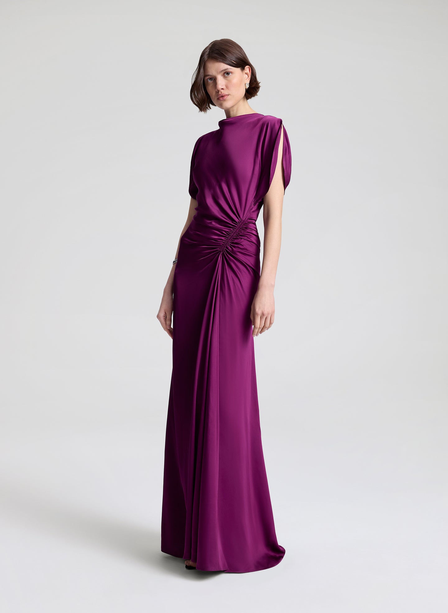 Woman wearing a long purple dress on a white background