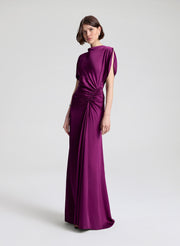 Woman wearing a long purple dress on a white background