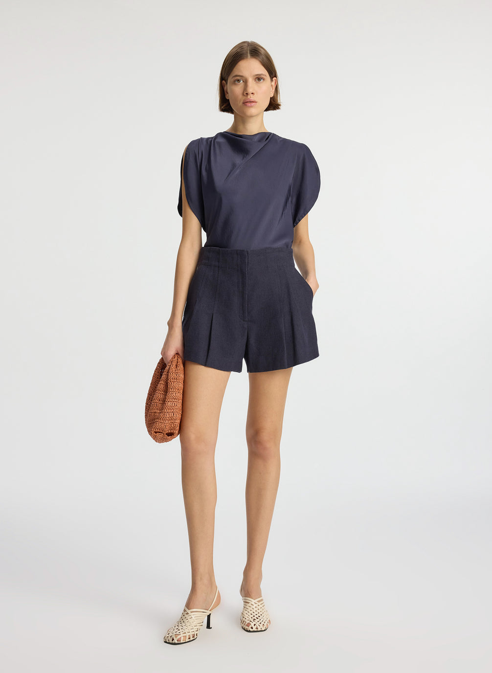 front view of woman wearing navy blue satin blouse and navy blue shorts