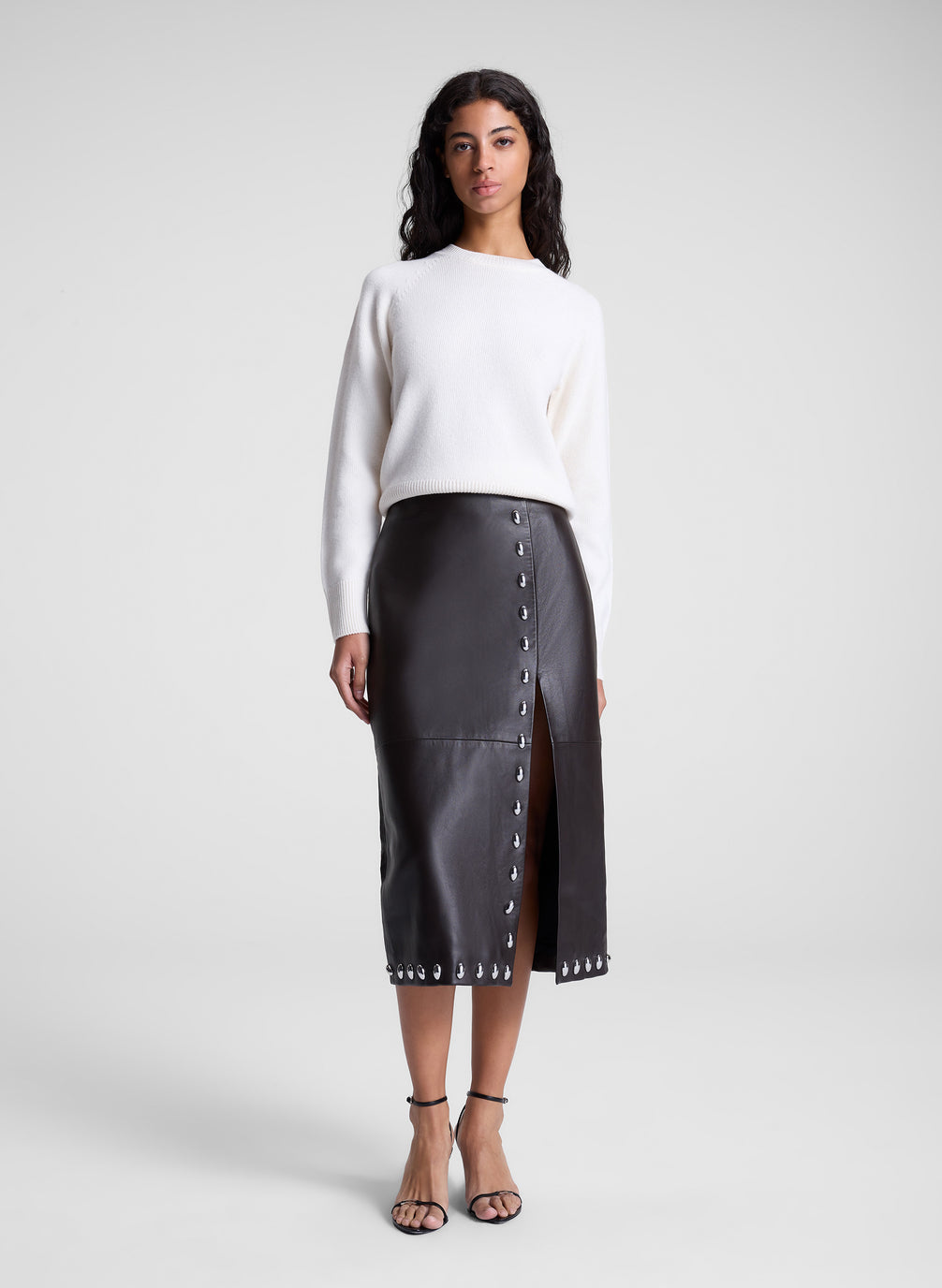 woman wearing white sweater and brown studded leather midi skirt