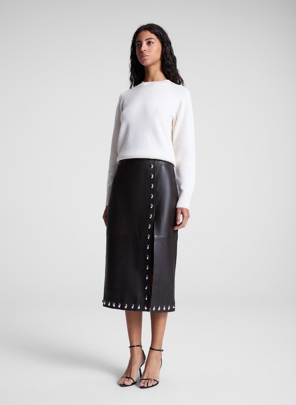 woman wearing white sweater and brown studded leather midi skirt