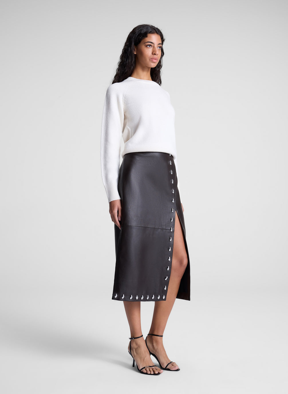 woman wearing white sweater and brown studded leather midi skirt