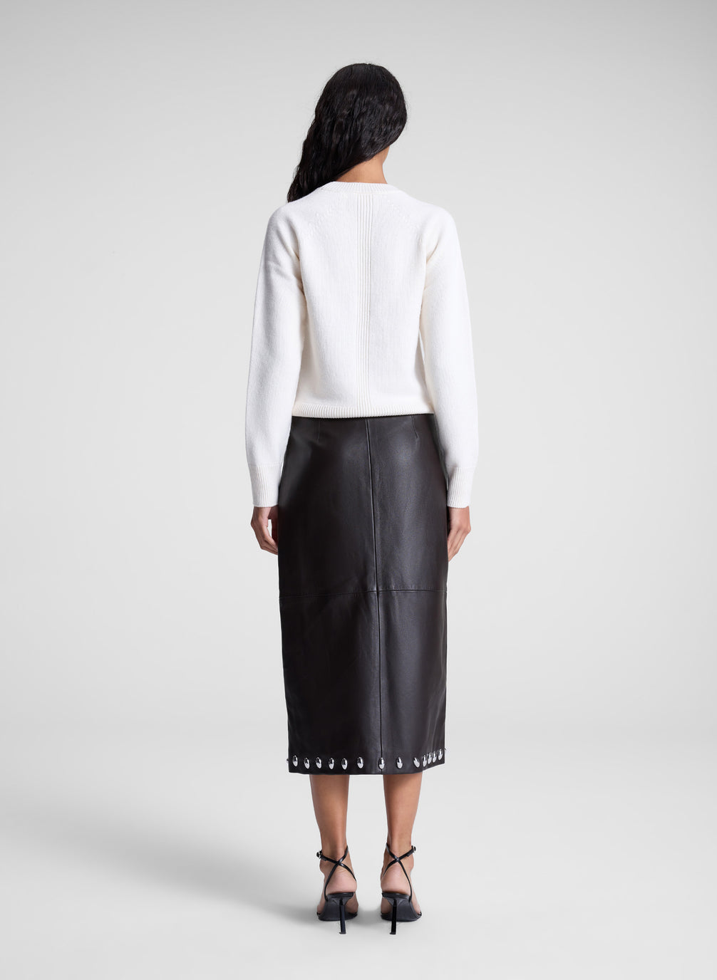 woman wearing white sweater and brown studded leather midi skirt