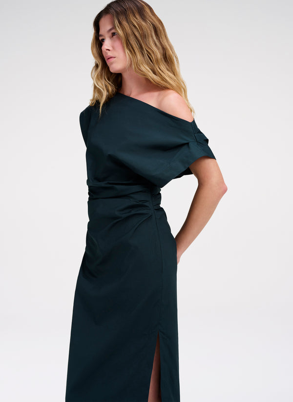 Woman wearing a dark teal off-shoulder dress on a white background