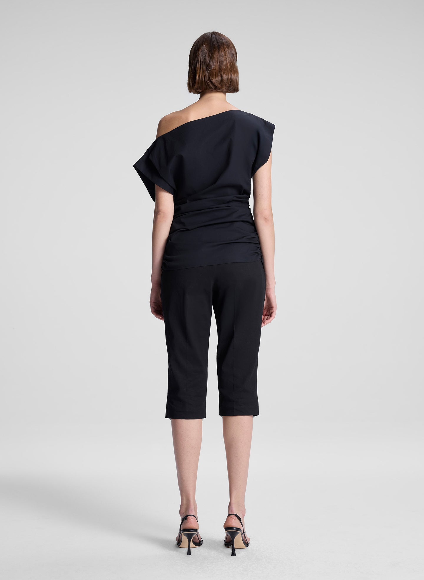 woman wearing black off the shoulder top and black capri pants