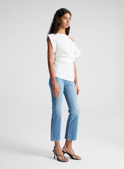 woman wearing white off the shoulder top and light blue denim jeans