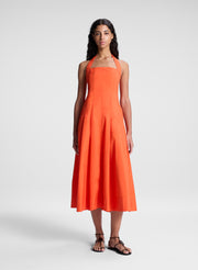 woman wearing orange halter midi dress