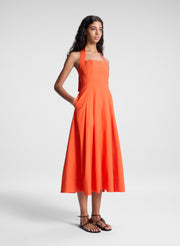 woman wearing orange halter midi dress