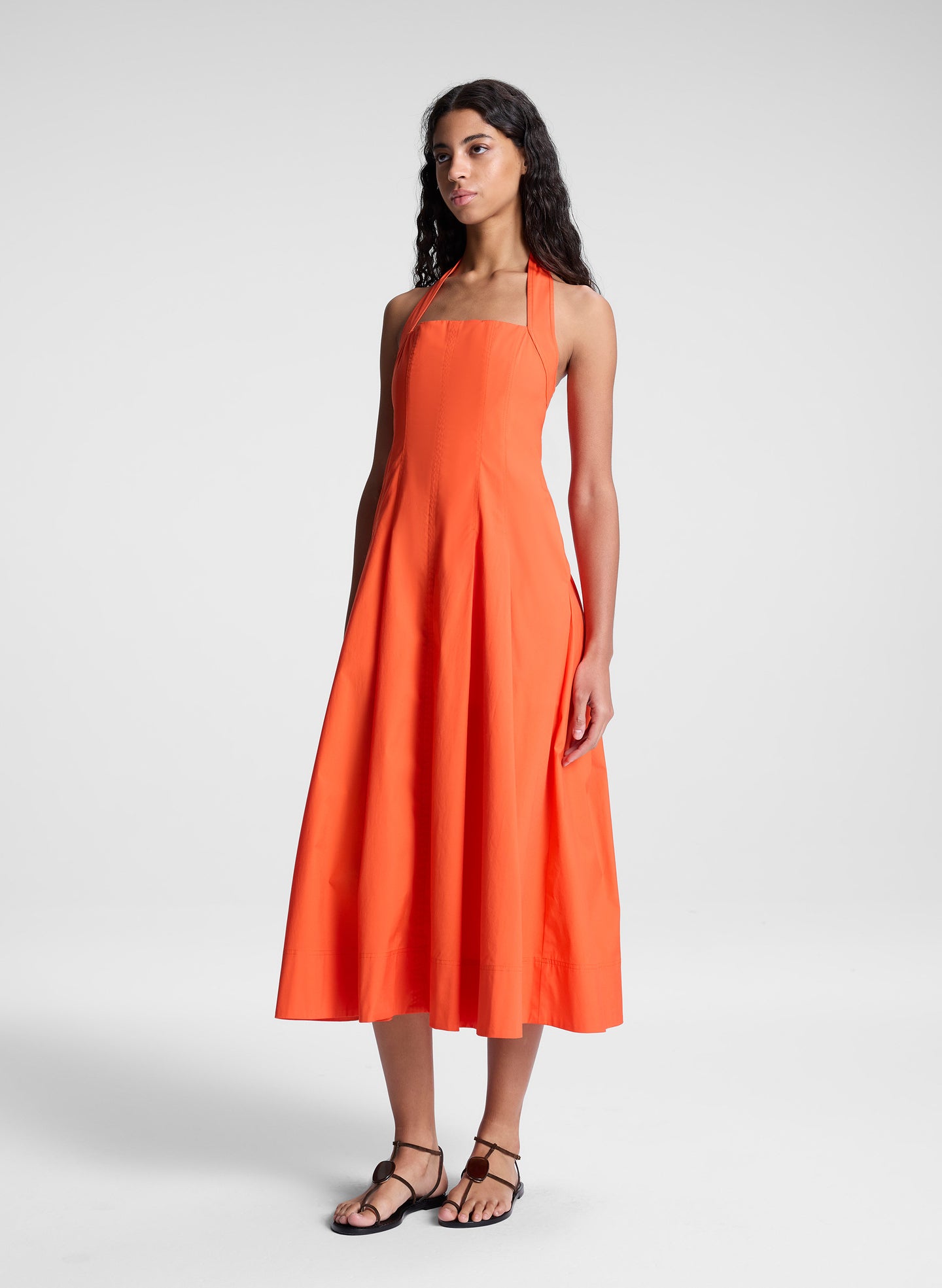 woman wearing orange halter midi dress