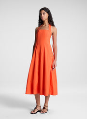 woman wearing orange halter midi dress